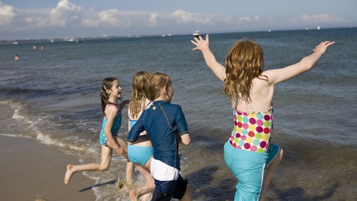 Children running into the sea at Studland Bay, Dorset